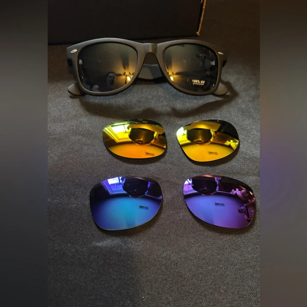 Sunglasses with three interchangeable lenses, dark, yellow, and blue.